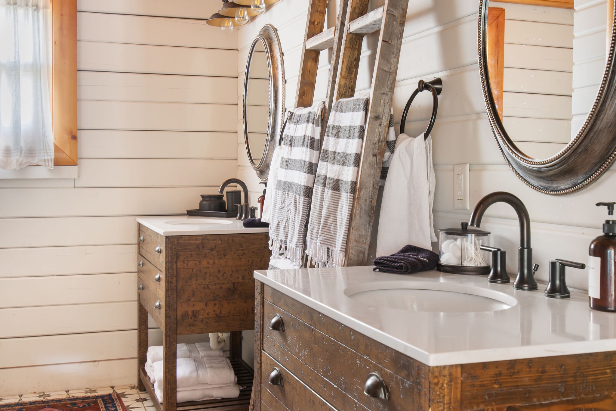 One of two full baths — twin vanities under round mirrors